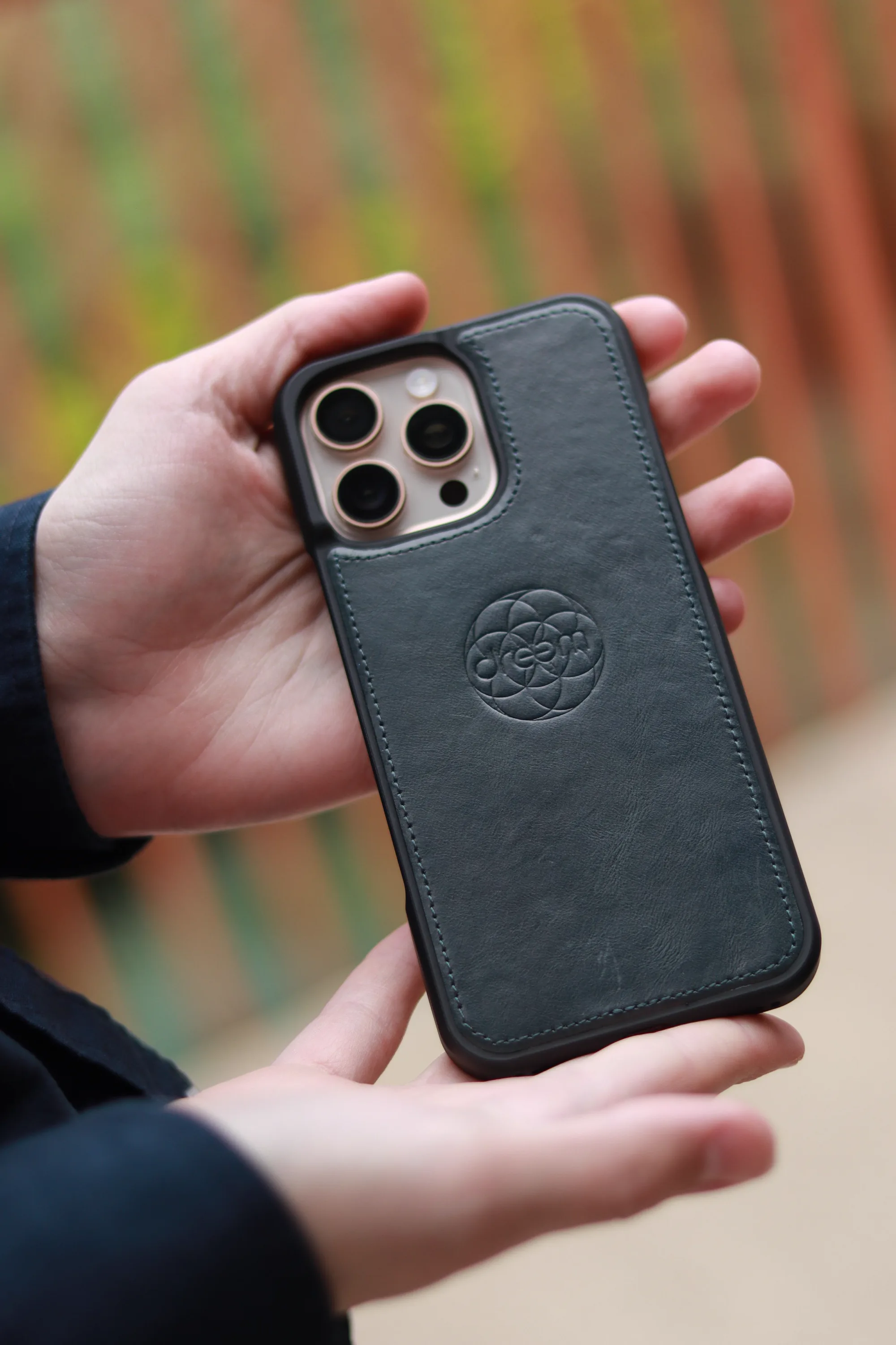 Close-up of a leather phone case with a circular embossed design