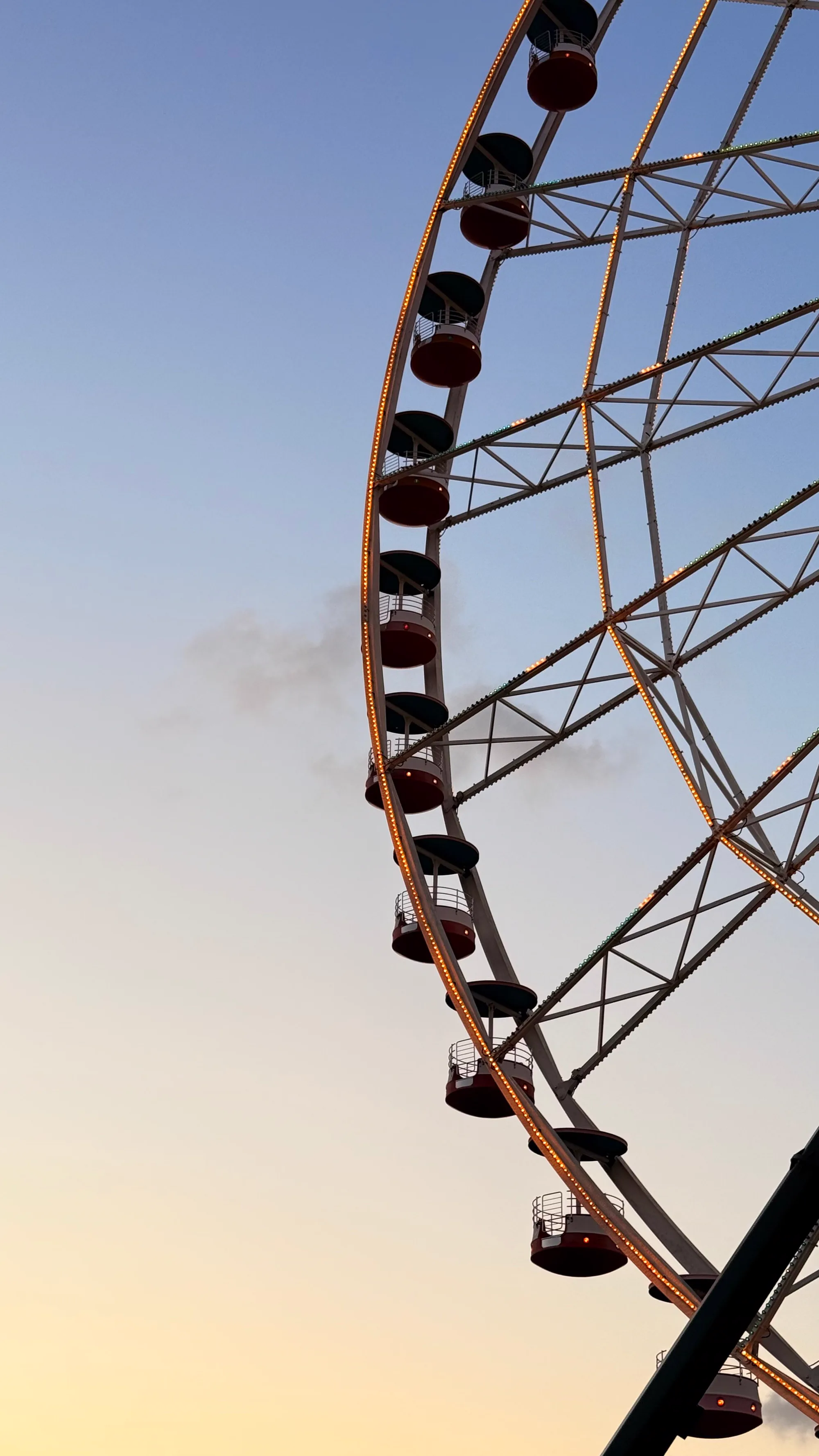A ferris wheel against a sunset sky