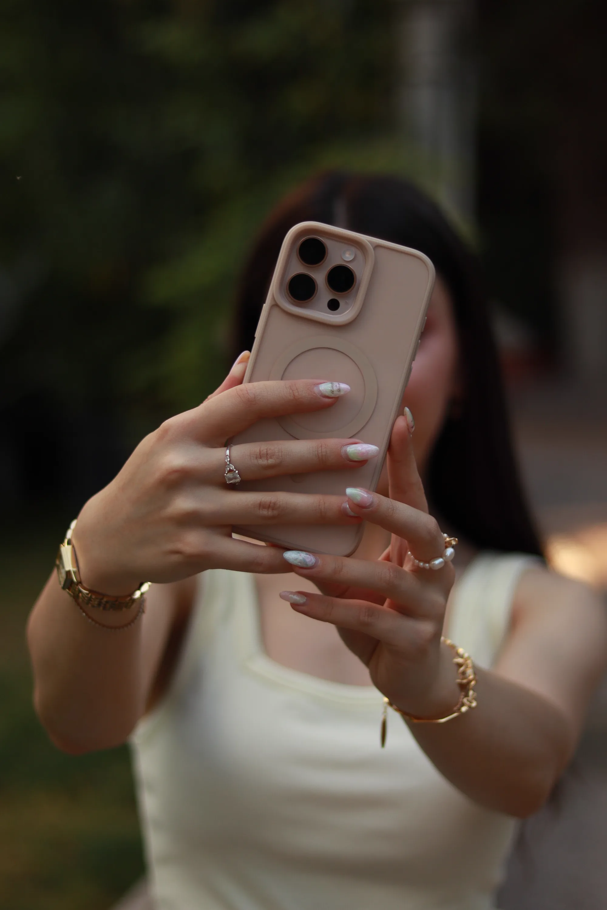 Taking a selfie with a smartphone, manicured nails and jewelry